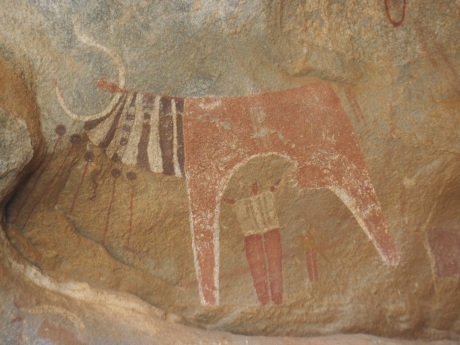 Cow and man painting at Las Geel.