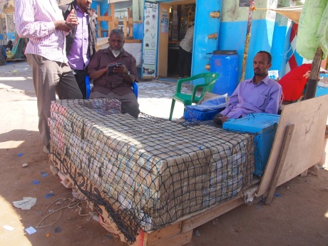 Money changer with a desk made of cash, Hargeisa, Somaliland.